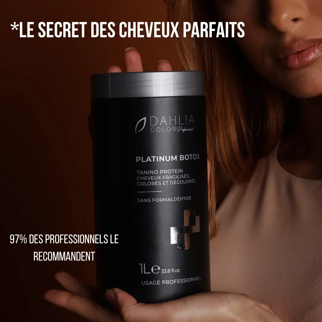 Une femme tient une grande bouteille noire de produit capillaire Platinium Botox sur un fond sombre, soulignant ce produit de coiffure professionnel pas cher au rapport qualité/prix excellent. Dahlia Color Professionnel