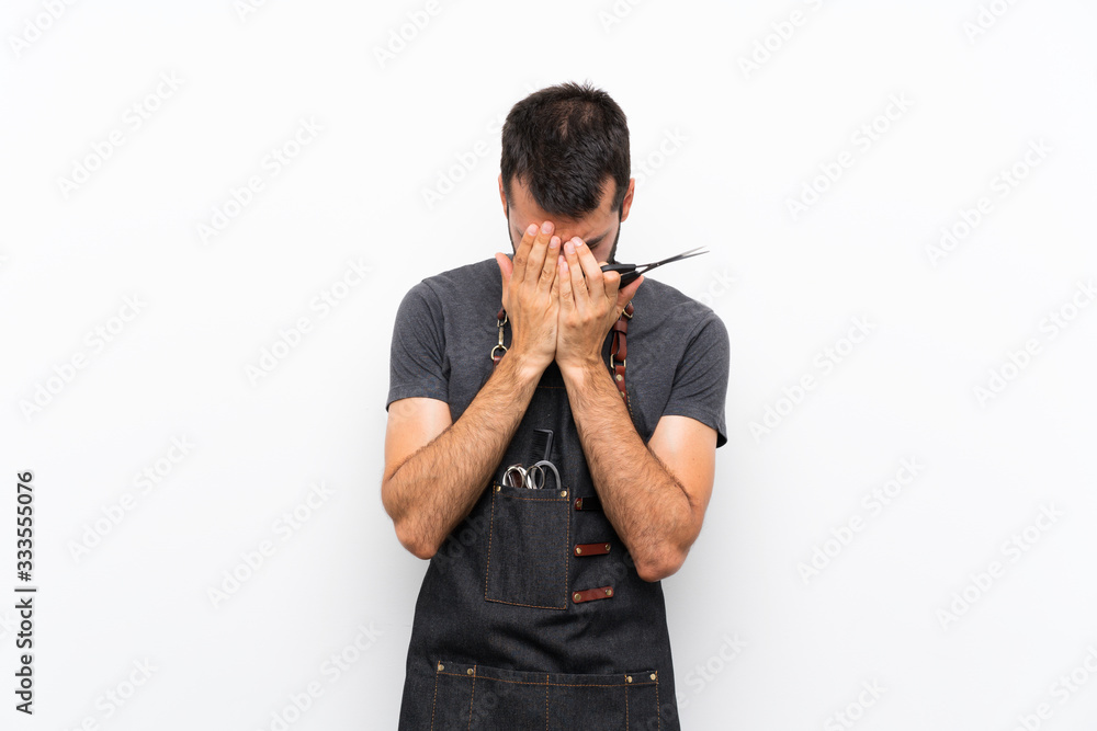 Coiffeur masculin en tablier couvrant son visage avec les mains, tenant des ciseaux, l'air stressé ou frustré. Dahlia Color Professionnel