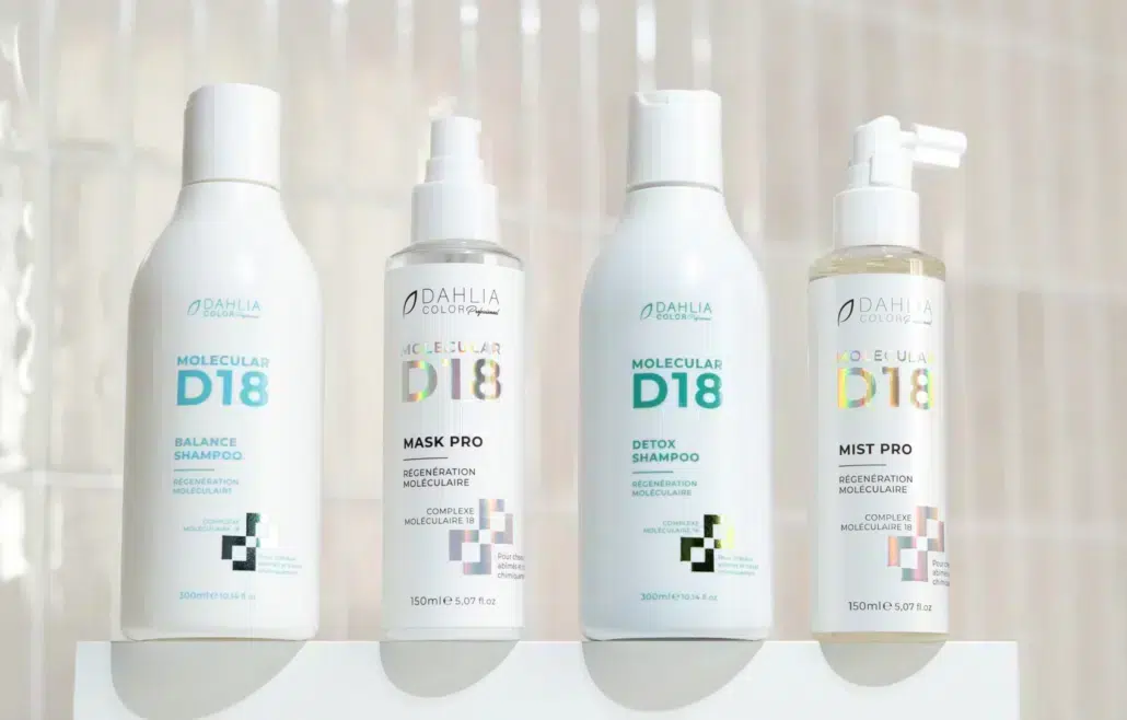 Quatre produits capillaires Dahlia Colour Molecular D18, dont des shampooings et une brume, présentés sur un fond clair. Dahlia Color Professionnel