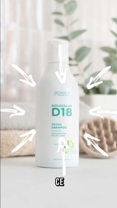 Une bouteille blanche de shampoing détox D18 se trouve sur un comptoir avec des flèches pointant vers elle. Dahlia Color Professionnel